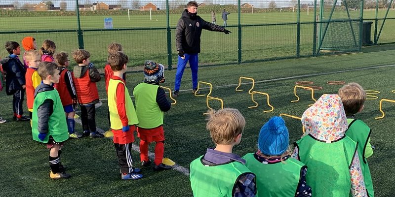 Fiesta sports coaching children at a football session